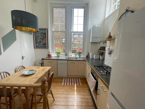 a kitchen with a wooden table and a table and a dining room at Spacious Holiday Home! in London