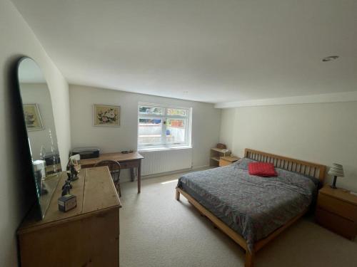 1 dormitorio con cama, escritorio y ventana en Spacious Holiday Home! en Londres