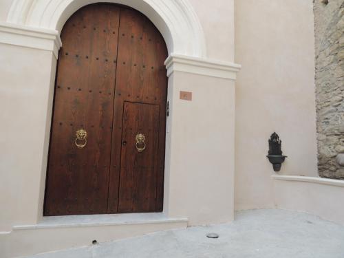 a large wooden door in a white building at Al Duomo B&B in Amantea