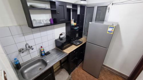 a small kitchen with a sink and a refrigerator at Smouha studo apartment - families only in Alexandria