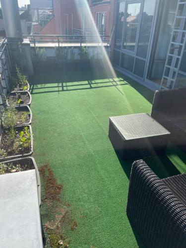 a balcony with green grass and benches on a building at Bayer's Boardinghouse und Hotel in Munich
