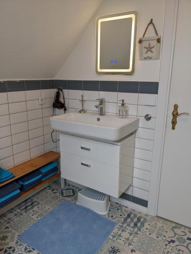 a bathroom with a sink and a mirror at Charmantes Ferienhaus in Nordfriesland in Humptrup