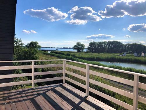 a wooden porch with a fence and a river at Pokoje Gościnne AKWARELA in Tarnobrzeg