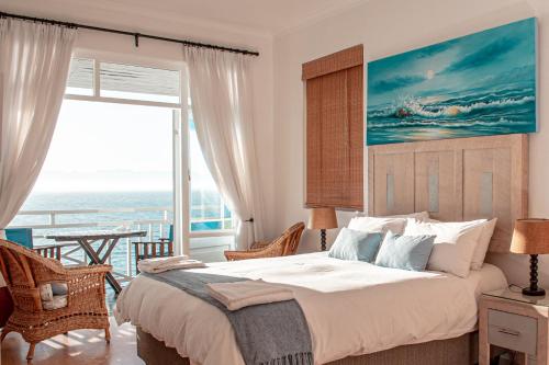 a bedroom with a bed with a view of the ocean at A Whale of a Time in Fish hoek