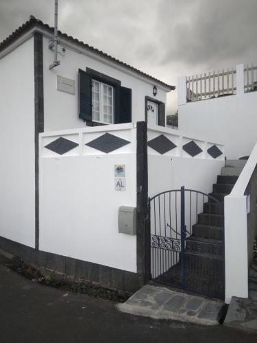 a white house with black and white tiles on it at Vitamin Sea in São Roque do Pico