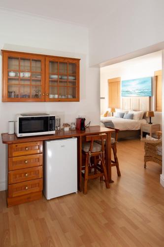 a kitchen with a table and a white refrigerator at A Whale of a Time in Fish hoek
