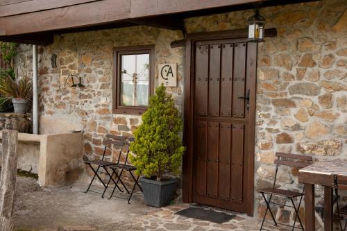 una puerta a un edificio de piedra con mesa y sillas en Casa Rural El Corquieu de la Cava en San Feliz