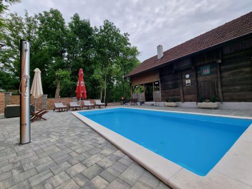 a swimming pool in front of a building with a house at Old House Zabok in Zabok