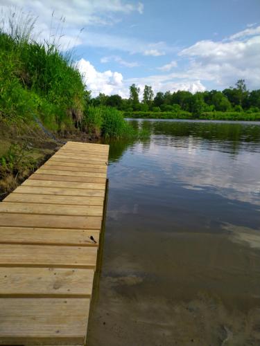 a wooden dock on a lake in the water at W Łęgu Natury in Nur