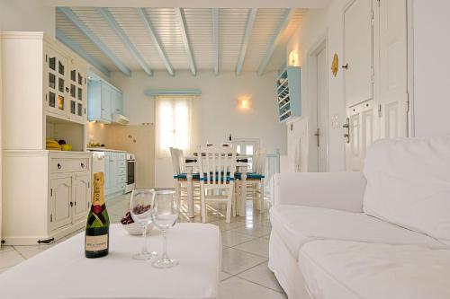 a living room with a bottle of wine and glasses on a table at Naxos Affinity Villas in Maragkas