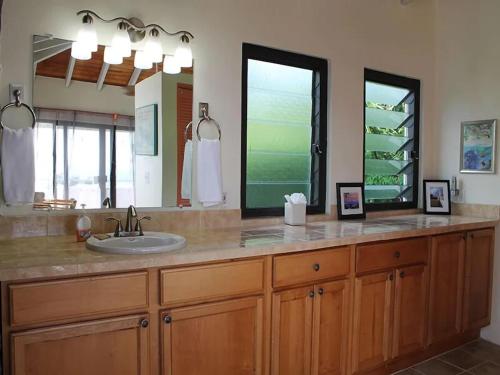 a bathroom with a sink and a large mirror at Serene Cruz Bay Villa Sep Mstr Kg Suite Stunning Sunsets in Cruz Bay