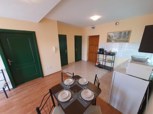 a kitchen with a table with plates on it at Cserke-Thermál Apartman in Cserkeszőlő