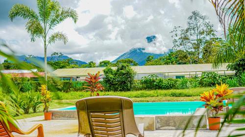 a patio with chairs and a swimming pool at Hotel Campestre Arenal in Fortuna