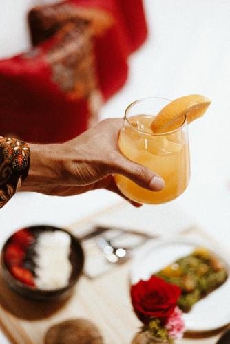 a person holding a glass with a orange slice on it at Amarla Boutique Hotel Casco Viejo in Panama City