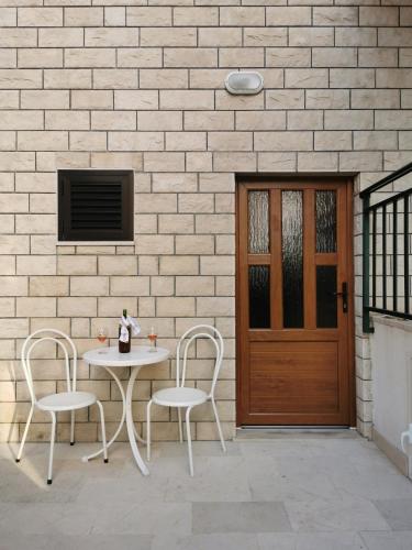 a table and chairs in front of a building with a door at Uncle Apartment in Makarska