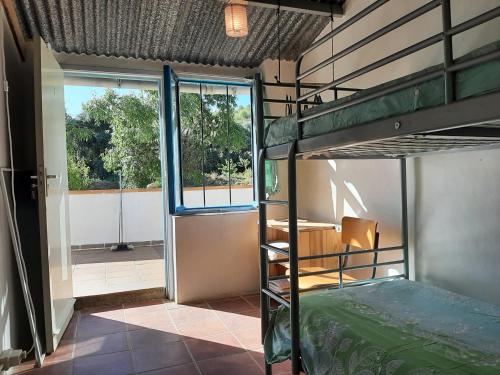 a bedroom with a bunk bed and a balcony at Vakantieboerderij La Balsa in Alquife