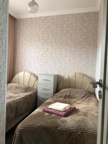um quarto com 2 camas e uma cómoda com uma toalha em Edgars apart. Бесплатный трансфер в аэропорт. em Tsaghkadzor