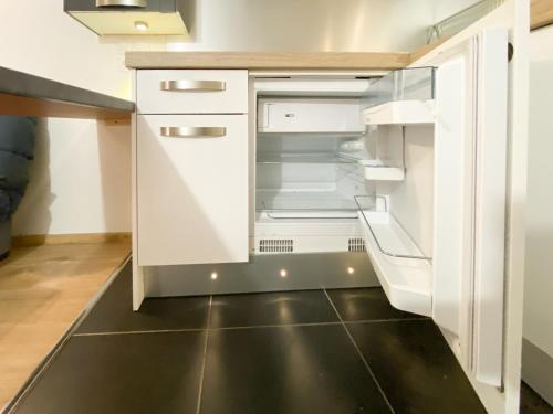 una cucina con armadi bianchi e frigorifero vuoto di LE PETIT RAMBOLITAIN a Rambouillet