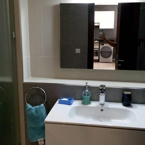 a bathroom sink with a mirror and a blue towel at Studio Tamourit Taghazout Bay à 300 m de la plage in Taghazout