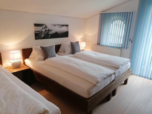 フューゲンにあるFerienwohnung Leitlのベッドルーム(ベッド2台、ランプ2つ付)