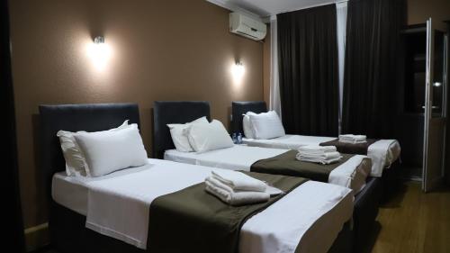 Un pat sau paturi într-o cameră la Grand Avenue Hotel