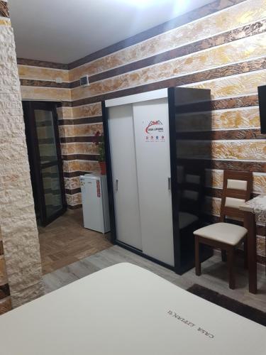 a room with a door and a chair and a table at Casa Lipianu in Târgu Jiu