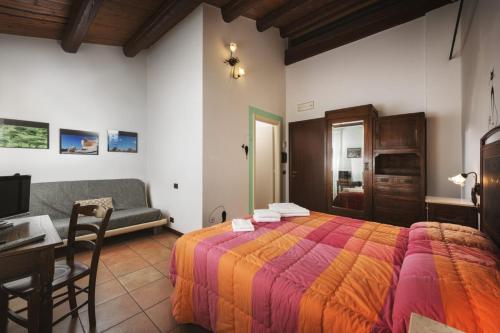 a bedroom with a bed and a table and a couch at Briciola di Sole b&b e ristorante in Borgo