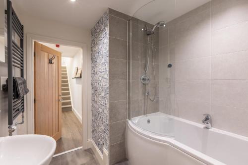 a bathroom with a tub and a toilet and a sink at The Servant’s Quarters in Whitby