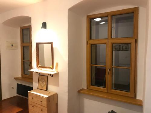 a bathroom with a mirror and some windows at Apartmán v Žltom dome in Banská Štiavnica