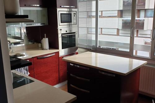 cocina con armarios rojos y encimera blanca en Appartement Lumineux de 90 m2 situé en centre ville, en Annecy