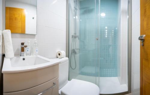 y baño con ducha, aseo y lavamanos. en Zurbarán Playa Ha Apartment, en Cádiz