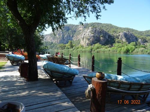 a group of boats on a dock next to a lake at Dalyan Riverside Private Gaia Koru Bungalows with Swimming Pool Adults Only in Ortaca