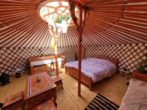 een kamer met een bed en een tafel in een yurt bij Clos Des Monts in Saint-Martin-des-Besaces
