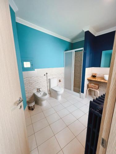 a bathroom with two toilets and a blue wall at DEAS B&B in Trani
