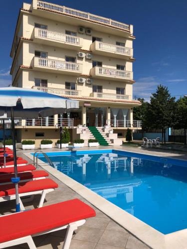 ein Hotel mit einem Pool vor einem Gebäude in der Unterkunft Relax Apartment & Hotel in Golem