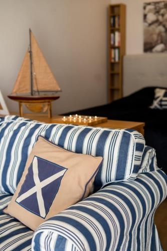 a couch with blue and white pillows in a living room at Lillmåsen Naantali - atmospheric and very comfy studio in Naantali