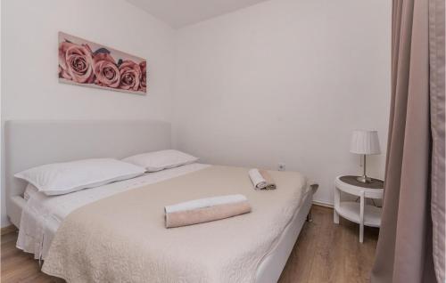 ein weißes Schlafzimmer mit einem Bett und einem Handtuch darauf in der Unterkunft Stunning Apartment In Nevidane With Wifi in Neviđane