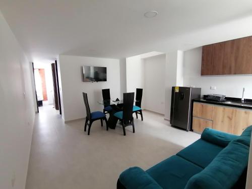 a living room with a blue couch and a table and chairs at Hermoso apartamento nuevo con estacionamiento gratuito in San Gil