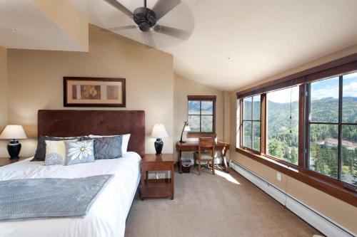 a bedroom with a bed and a desk and windows at Purgatory Lodge Unit 501 in Durango Mountain Resort