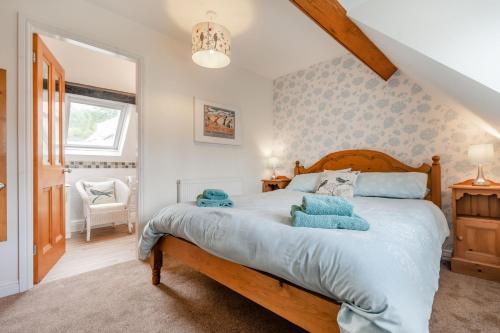 a bedroom with a bed with blue towels on it at Brincliffe Cottage in Robin Hood's Bay