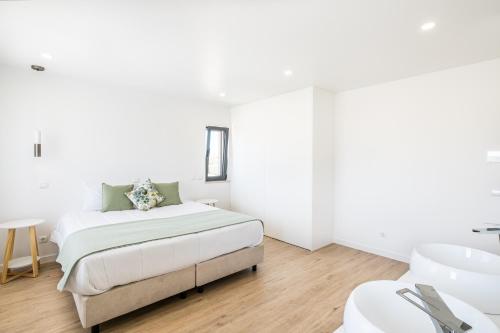 Habitación blanca con cama y lavabo en Atlantis Luxury Villa by Atlantic Places, en Albufeira