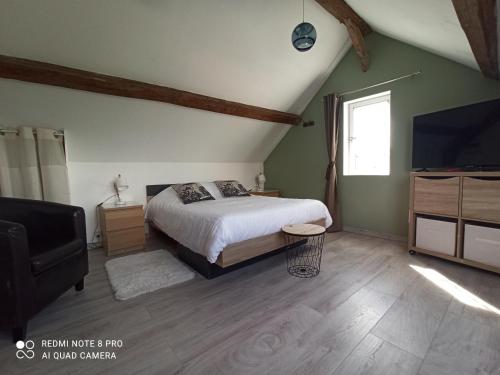 une chambre avec un lit et une télévision à écran plat dans l'établissement Le nid perché, à Honfleur