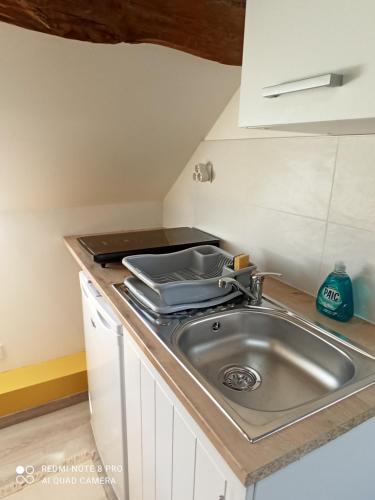 une cuisine avec un évier et un plan de travail dans l'établissement Le nid perché, à Honfleur
