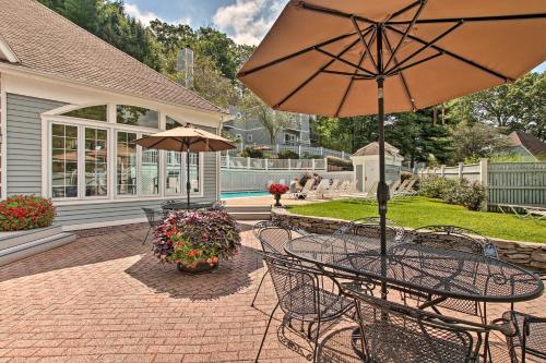 a patio with a table and chairs and an umbrella at Lovely Norwich Villa, On Golf Course with Amenities! in Norwich