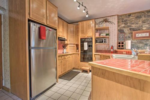 a kitchen with wooden cabinets and a stainless steel refrigerator at Historic Helena Retreat - Near Dtwn and Mt Helena! in Helena