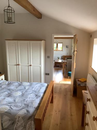 1 dormitorio con 1 cama grande y cocina en Woodcutters Barn, overlooking Ledbury & Malvern Hills, en Ledbury