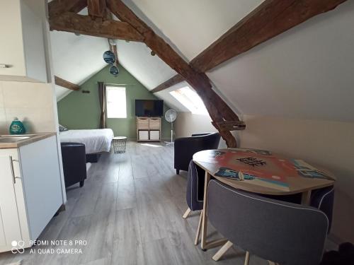 une chambre avec un lit et une table avec des chaises dans l'établissement Le nid perché, à Honfleur