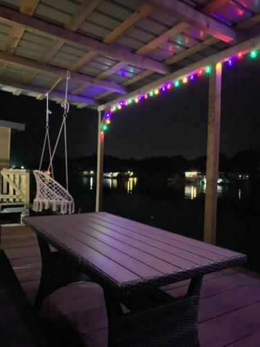 a picnic table on a deck at night with lights at Pearl Cottage Ada Bojana in Ulcinj