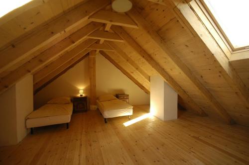 ポランチクにあるBiały Wierch Bieszczadyのベッド2台と窓が備わる屋根裏部屋です。