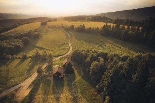 Lewin Kłodzki的住宿－Dziewięćsił Blisko ziemi Góry Stołowe Duszniki Zdrój，田间中带路的房子